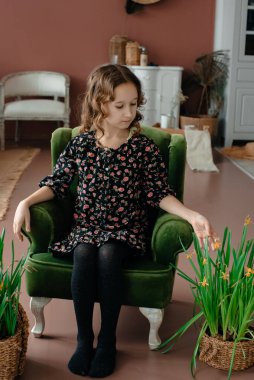 Sandalyede poz veren sevimli küçük kız. 