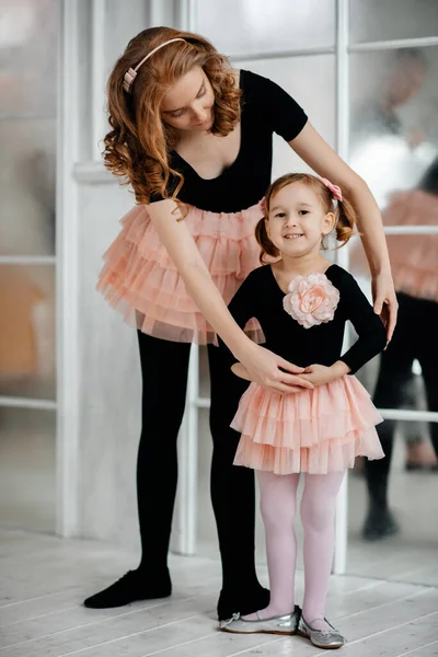Children's choreography. Mom spends free time with her daughter. Little girl and sport.