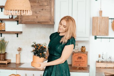 Sarışın kadın mutfakta poz veriyor.