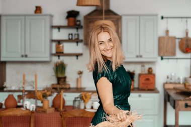 Sarışın kadın mutfakta poz veriyor.