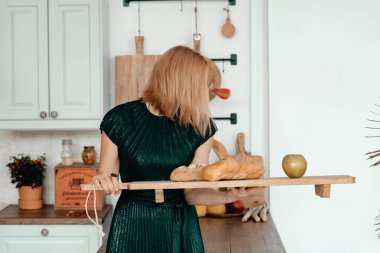 Sarışın kadın mutfakta poz veriyor.