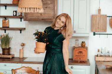 Sarışın kadın mutfakta poz veriyor.