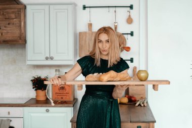 Sarışın kadın mutfakta poz veriyor.