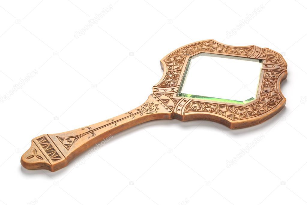 Vintage carved wooden mirror lies on a white background