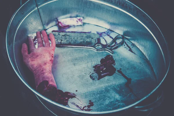 Hand amputated by a medical saw, as an illustration of the work of doctors during the war or illegal activities of surgeons or crime scene. Toned image — Stock Photo, Image