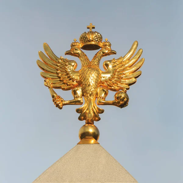 Golden Coat of arms of the Russian Federation close-up on the background of the sky