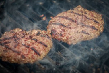 Dumanla hamburger Barbekü üzerinde kavurma lezzetli ve iştah açıcı sığır eti ızgara