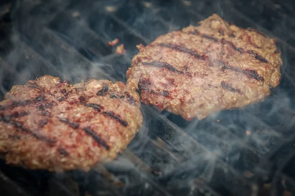 Dumanla hamburger Barbekü üzerinde kavurma lezzetli ve iştah açıcı sığır eti ızgara