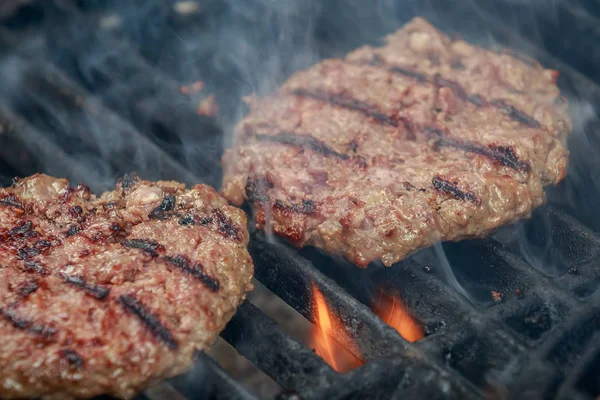 Hambúrgueres de carne suculentos e apetitosos assam na grelha da grelha — Fotografia de Stock