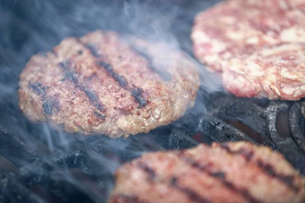 Étvágygerjesztő marhahúsos hamburgerek pörkölés Bbq grill-füst — Stock Fotó
