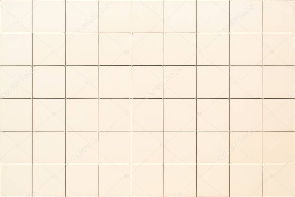 Decorative square beige tile on the facade of the building as a background or backdrop