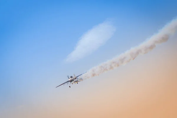 Light aeroplane flies down leaving behind itself a dark smoke as an illustration of crash of private jet