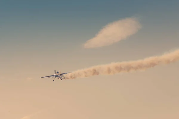 Licht vliegtuig vliegt naar beneden achterlating van zichzelf een donkere rook als een illustratie van de crash van prive-jet. Getinte afbeelding — Stockfoto