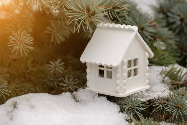 Oyuncak beyaz çam dalı ile kar üzerinde güneşli bir günde evim