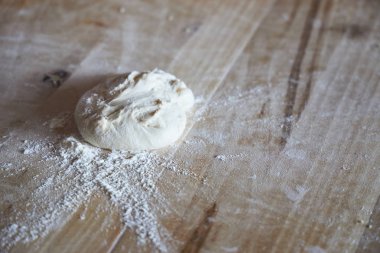 Tahta masaya serpiştirilmiş un serpiştirmek için tereyağı hamuru.