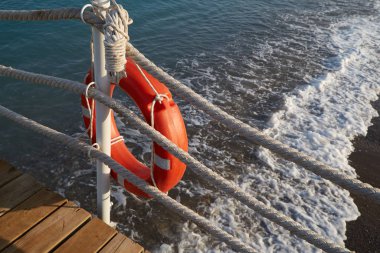 İpli bir can simidi denizde boğulan bir adamı kurtarır.