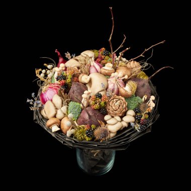 Siyah arka planda çeşitli sebzelerden oluşan bir buket şeklinde alışılmadık bir hediye.