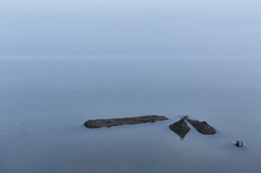 Mavi deniz gökyüzü ile birleşir sabahın erken saatlerinde mutlak bir sükunetle