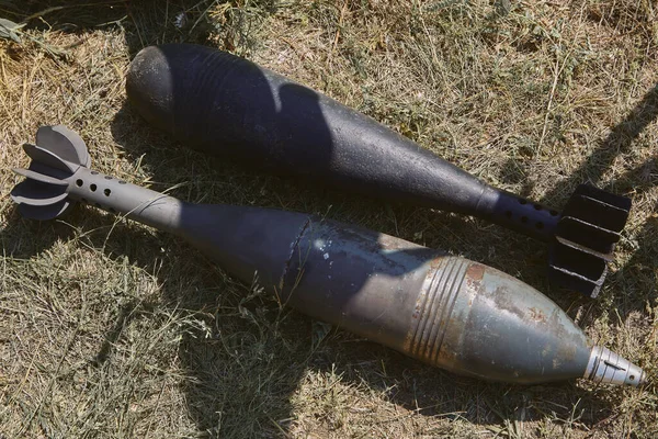 Two unexploded aerial bombs lie on the ground