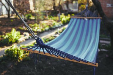 Ağaçların arasında asılı boş mavi hamak