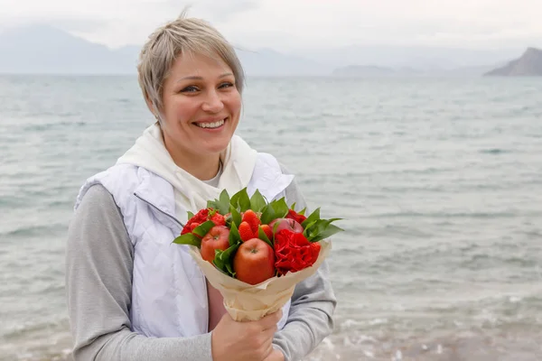 Mujer Con Sonrisa Complace Con Ramo Presentado Flores Frutas Imagen de stock