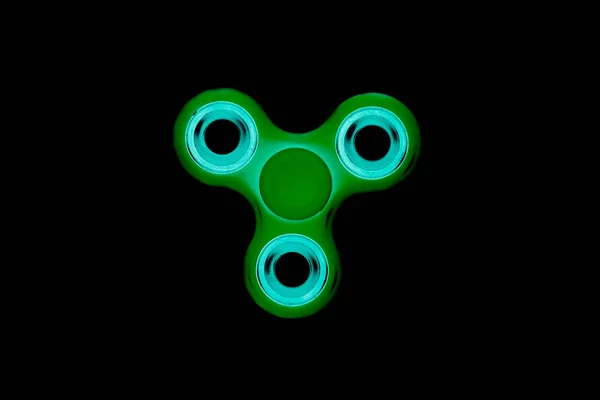 Green Fidget Spinner en fondo negro aislado para liberar estrés durante el trabajo — Foto de Stock