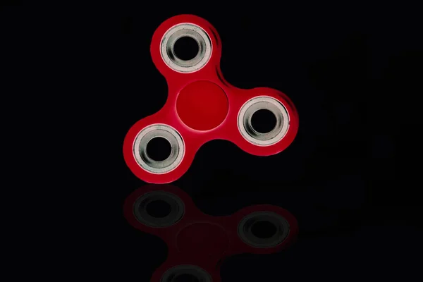 Red Fidget Spinner en fondo negro aislado para liberar estrés durante el trabajo — Foto de Stock