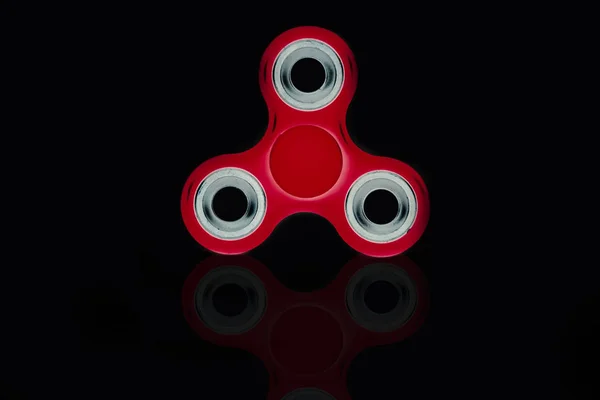 Red Fidget Spinner en fondo negro aislado para liberar estrés durante el trabajo — Foto de Stock