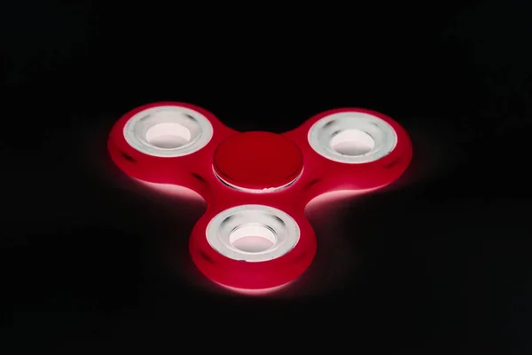 Red Fidget Spinner en fondo negro aislado para liberar estrés durante el trabajo — Foto de Stock