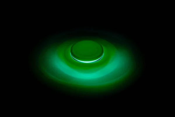 Green Fidget Spinner en fondo negro aislado para liberar estrés durante el trabajo — Foto de Stock