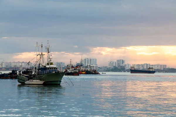 Alba in riva al mare con vista di barche commerciali e da pesca — Foto Stock