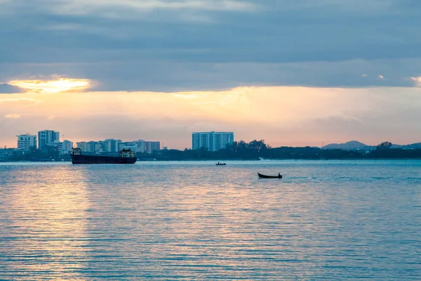 Nascer do sol pela costa com vista para o barco comercial e de pesca — Fotografia de Stock