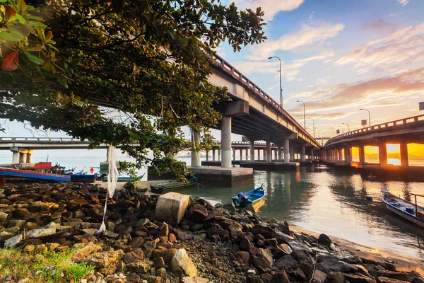 Bajo un puente de hormigón junto a la orilla durante el amanecer — Foto de Stock