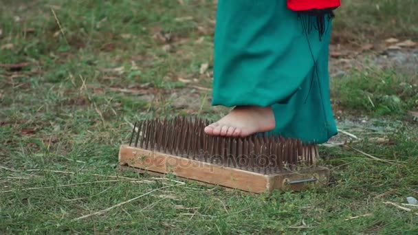 Men stand on the board with nails. Slow motion — Stock Video