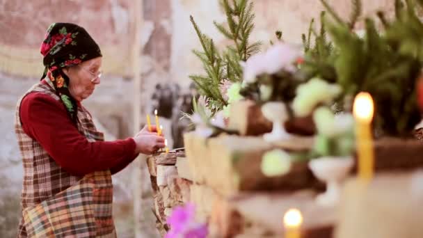 Γυναίκα προσευχής φωτισμός κεριών σε μια εγκαταλειμμένη εκκλησία — Αρχείο Βίντεο