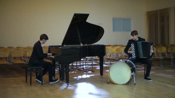 Дуэт пианист и аккордеонист, играющий музыку в пустой комнате — стоковое видео