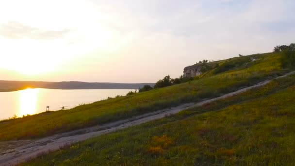 Aerial shot of a sunset near rocks. Vivid colors are reflected in the water — Stock Video