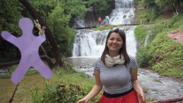 Mooi meisje praten in de buurt van de waterval — Stockvideo