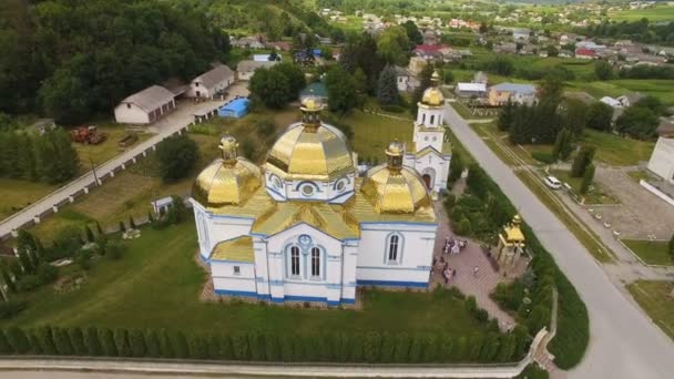 Tiro aéreo, voando perto de uma igreja cúpula fundo aldeia e floresta — Vídeo de Stock