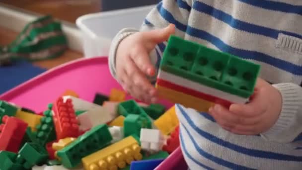 Mother playing with her baby boy in room with colourful blocks, balls, kitchen — Stock Video