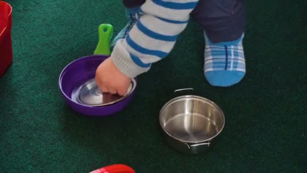Маленький мальчик играет с большим количеством красочных пластиковых блоков, шарики, кухня в комнате — стоковое видео