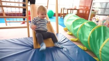 Onun bebek çocuk renkli bloklar, toplar, mutfak oda ile oynarken annesi