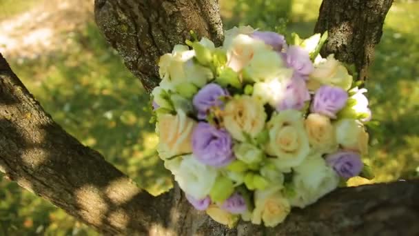 Bukiet ślubny zawiązany tasiemkami do huśtawki pod drzewem — Wideo stockowe