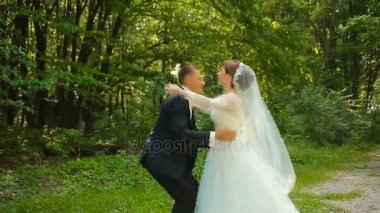Mutlu damat ve yeşil ormanda dans beyaz elbiseli güzel gelin