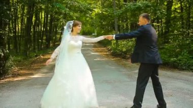 Mutlu damat ve yeşil ormanda dans beyaz elbiseli güzel gelin