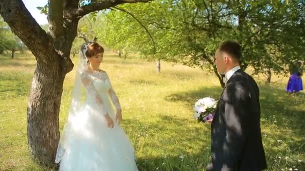 Ο γαμπρός δίνει η νύφη ένα μπουκέτο στέκεται σε ένα γόνατο στη φύση — Αρχείο Βίντεο