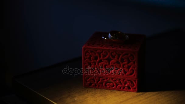 Anillos de boda en textura de madera oscura en lumplight. Joyería de boda . — Vídeo de stock