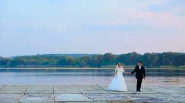Gelin ve Damat Düğün yürüyüşe göle karşı kucaklamak