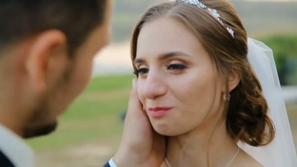 Primer plano de la novia y el novio intercambio de anillos de boda sobre fondo de la naturaleza verde — Vídeo de stock