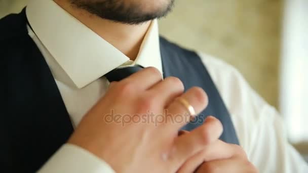 Man in white shirt tying a tie near the window. Close-up — Stock Video